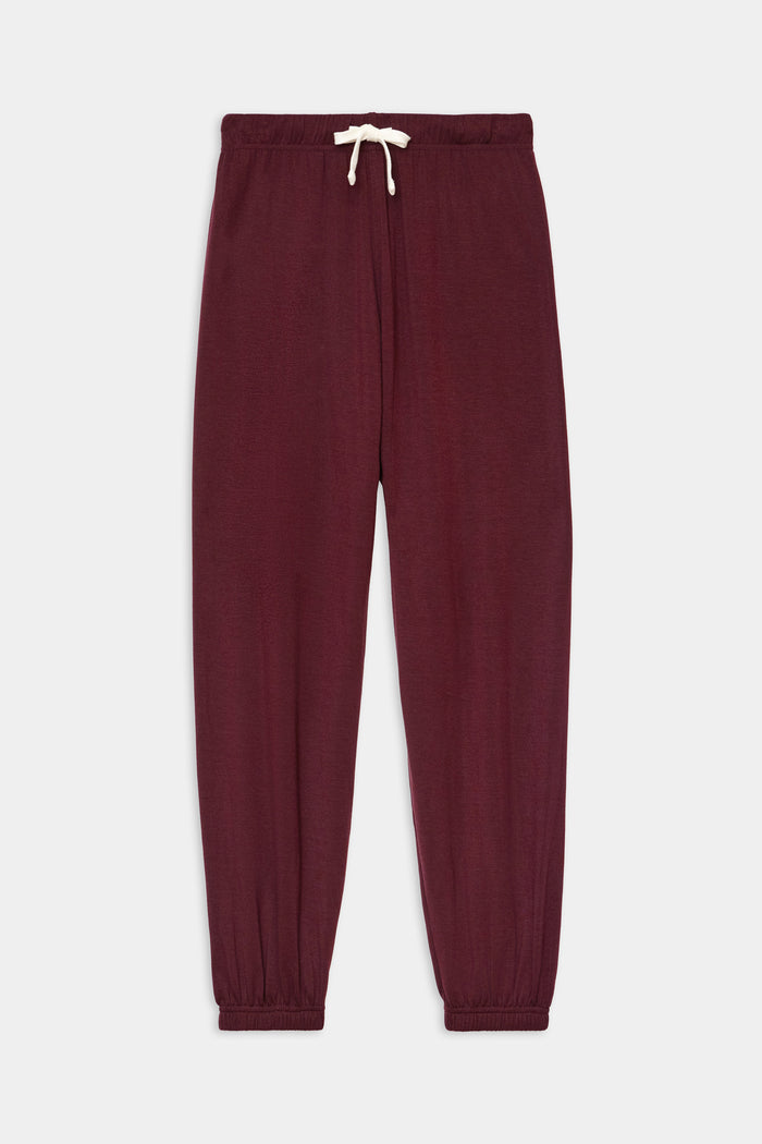 The SPLITS59 Andie Oversized Fleece Sweatpant in Dark Cherry features an elastic waistband, white drawstring, and ribbed cuffs, delivering ultra-luxe comfort for cool weather workouts—shown against a plain grey background.