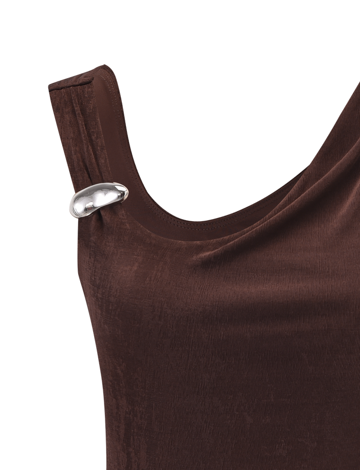 A close-up of the TIGERMIST CASSIAN TOP - CHOCOLATE, a velvet tank top with a silver oval-shaped decorative pin near the left shoulder.