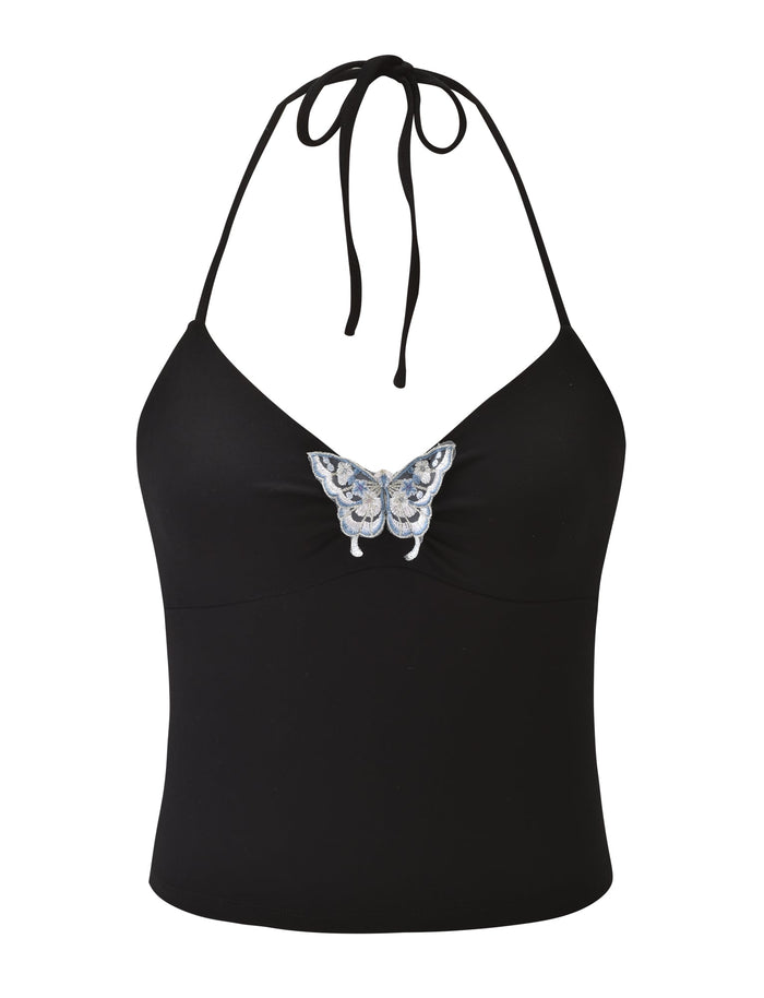 The TIGERMIST CELESTINE TOP - BLACK is a fitted halter top with thin tie straps at the neck and a blue and white embroidered butterfly centered on the chest.