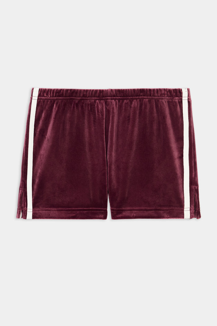 The SPLITS59 Heritage Velour Short in Dark Cherry/White features soft polyester-spandex fabric, white side stripes, and an elastic waistband, shown on a plain white background.