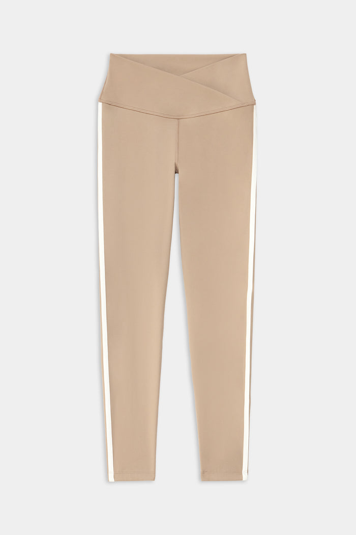 The SPLITS59 Mia Rigor Legging w/ Stripe in Latte/White features a high-waisted crisscross waistband, nylon blend fabric, and white vertical side stripes, shown laid flat on a white background.