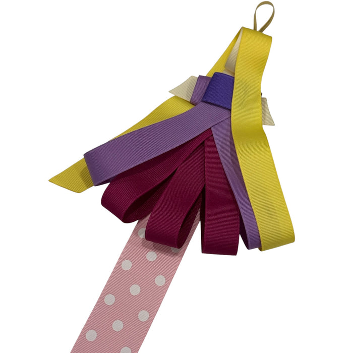 Close-up of purple and burgundy princess-inspired bow clips on ribbon hanger