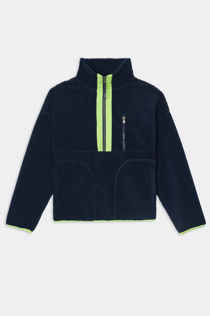 Introducing the SPLITS59 Reese Sherpa Half Zip Pullover in Indigo/Limeade—a cozy navy blue fleece crafted from soft 100% polyester, featuring a high collar, neon limeade zipper, front pocket, and vibrant limeade lining on the cuffs and interior for added warmth and comfort.