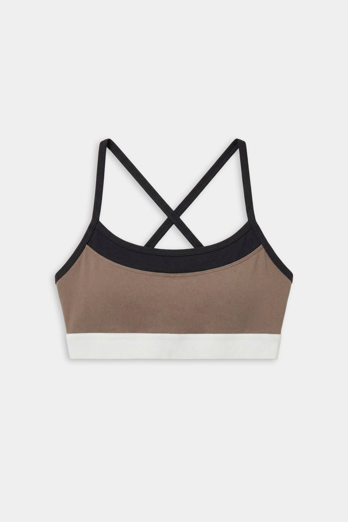 The SPLITS59 Scottie Airweight Bra in Lentil/Black is a colorblock sports bra with black straps, a tan front panel, black trim, and a white bottom band, made from spandex and nylon. Displayed on a white background.