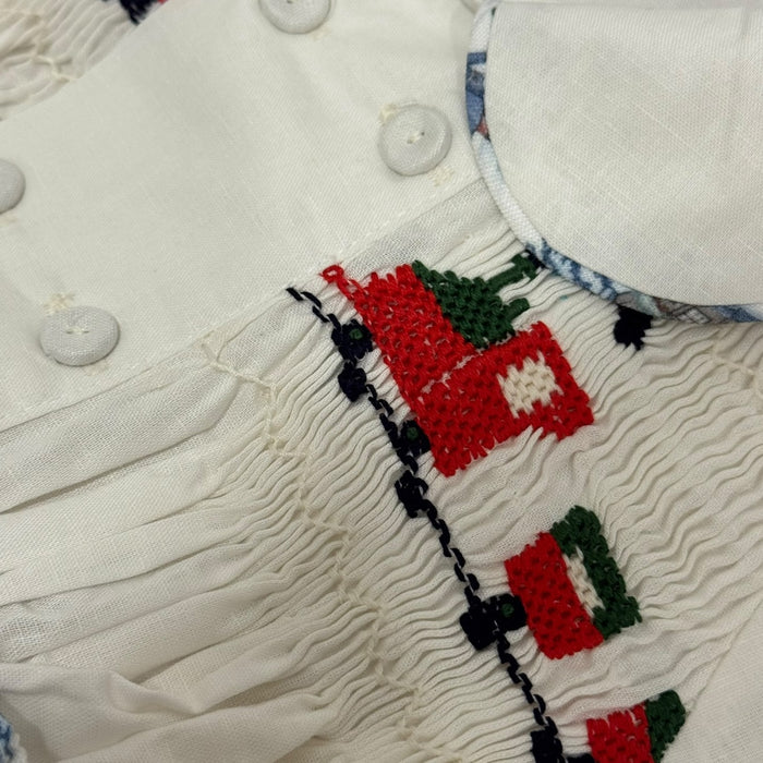 Close-up of red-and-green handsmocked train detailing on The Polar Express 2-piece set