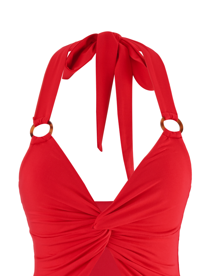 A close-up of the TIGERMIST ZENEVA TOP - RED, a halter-neck swimsuit in buttery jersey, featuring a twisted knot front and two tortoise shell ring accents at the straps.