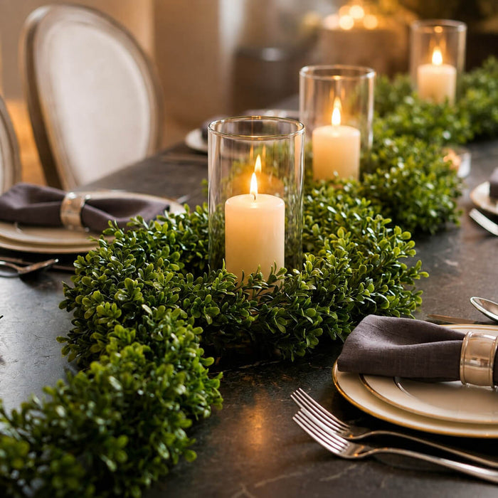 9ft faux boxwood garland used as a dining table centerpiece with pillar candles