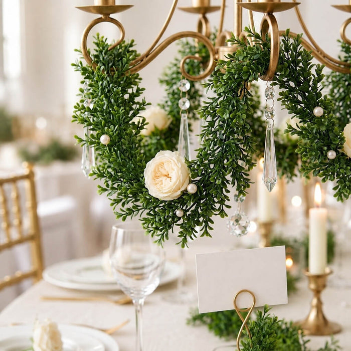 9ft faux boxwood garland wrapped around a chandelier with white roses and crystals