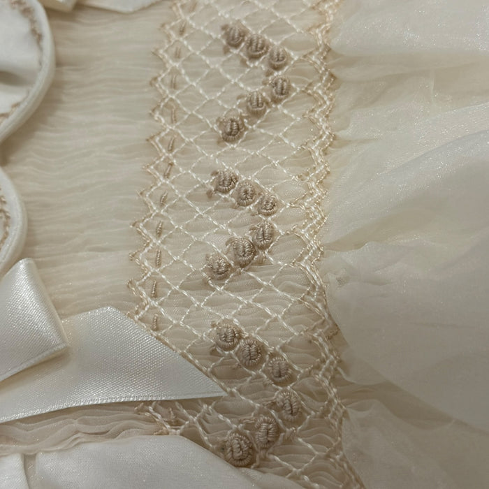 Close-up of intricate ivory handsmocking on Adrian Boy Romper