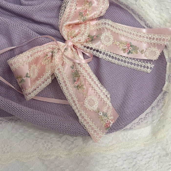 Close-up of pink floral bow on Aida Rose Luxe Purple Knitted Blanket