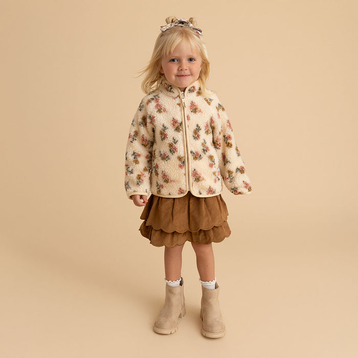 Girl standing, full body, wearing the Amber print sherpa zippered jacket