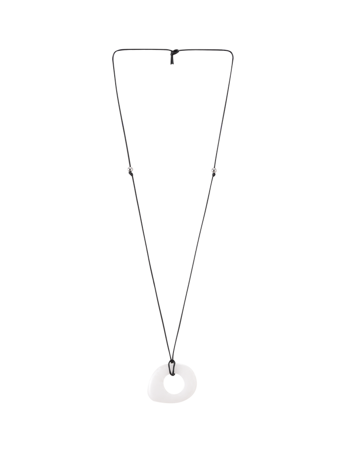 The TIGERMIST AMYRA PENDANT NECKLACE - WHITE features a minimalist adjustable black cord with a smooth, irregular white pendant at the center, drawing attention to its unique design against a plain background.