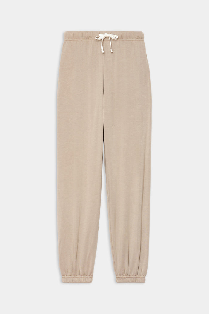 The SPLITS59 Andie Oversized Fleece Sweatpant in Latte features an elasticated waistband and cuffs, perfect for warm-ups or cool weather workouts, shown laid flat on a white background.