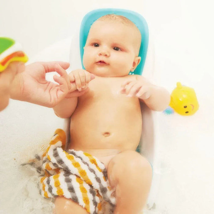 Baby relaxing in a blue tub with Angelcare Bath Support Fit for comfy bath time