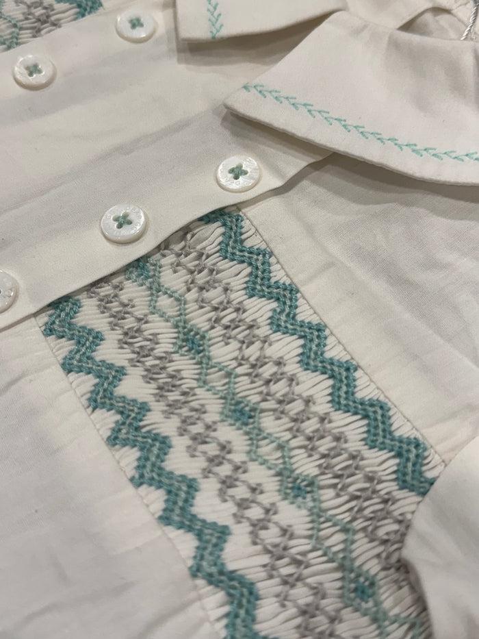 Close-up of mint handsmocking, rounded collar and button detailing on August Mint Boy Set