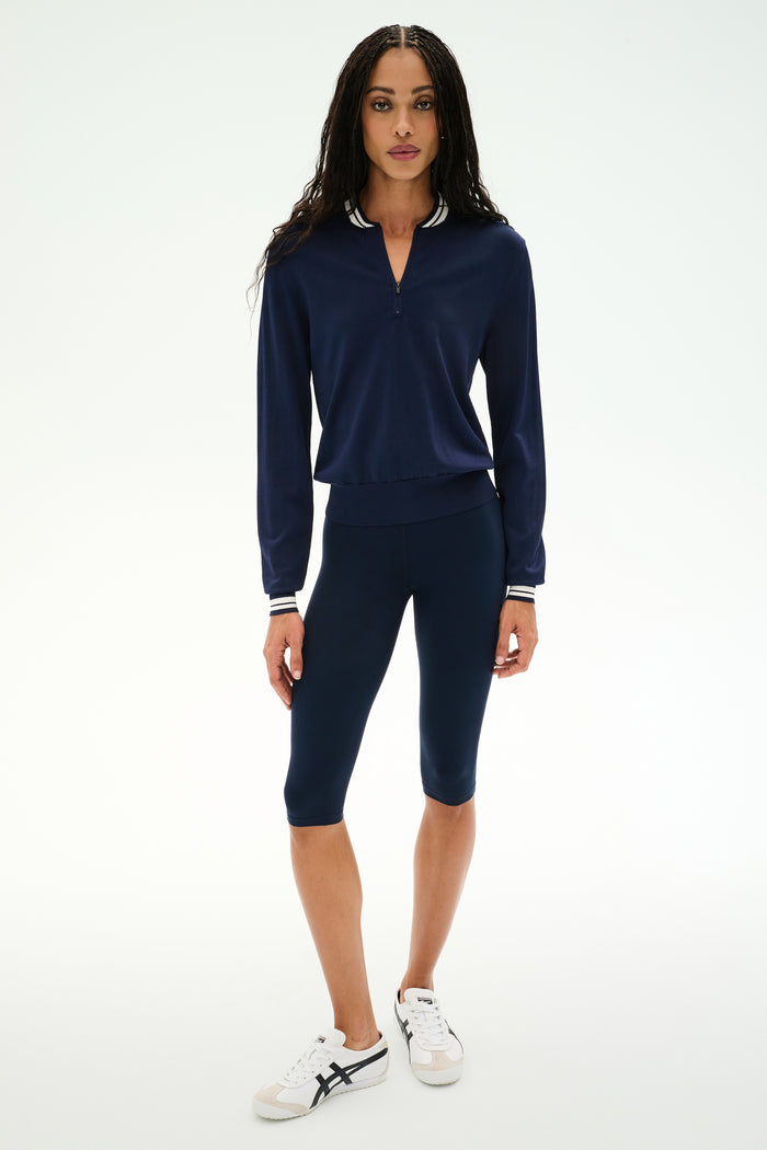 A person wearing the SPLITS59 Bonnie Knit Half Zip in Indigo/White stands against a plain white background.