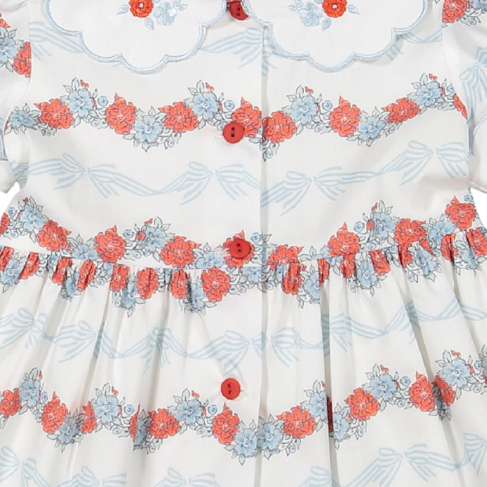 Close-up of scalloped collar, red button details and Breeze floral-and-bow print