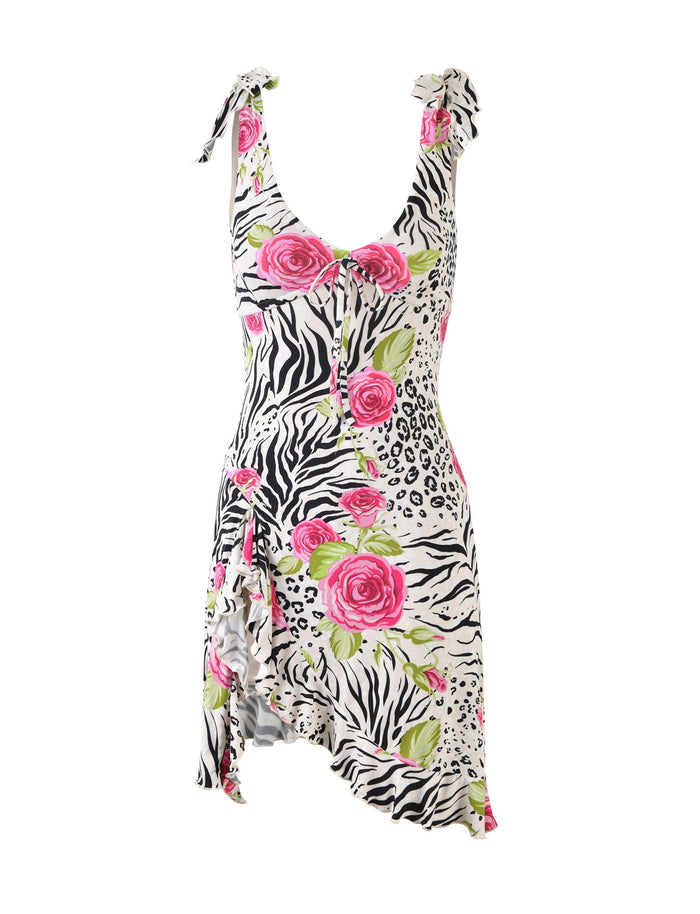 The BRYNNE DRESS - MULTI: ZEBRA from TIGERMIST is a sleeveless piece featuring an asymmetric hem and shoulder ties. This bold creation is adorned with a striking zebra print, large pink roses, and green leaves, enhancing its summery and vibrant look.