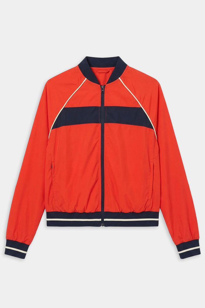 The SPLITS59 Carrie Woven Nylon Jacket in Lotus Red/Indigo features navy and white stripes, ribbed cuffs and waistband, two front pockets, and a comfy nylon-spandex blend, shown against a white background.