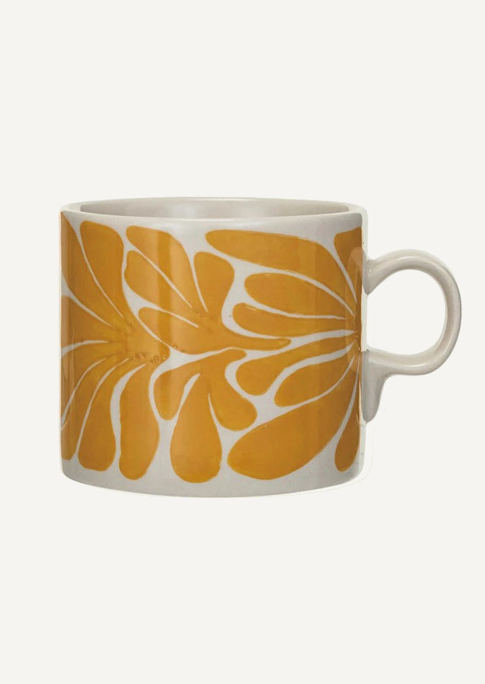 A white ceramic mug with yellow seaweed pattern.