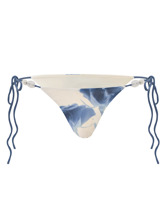 The TIGERMIST CYLAS BIKINI BOTTOM - INDIGO FLORAL features a blue and white marbled pattern with wavy blue side straps, offering a stylish update to classic florals. Shown against a white background.