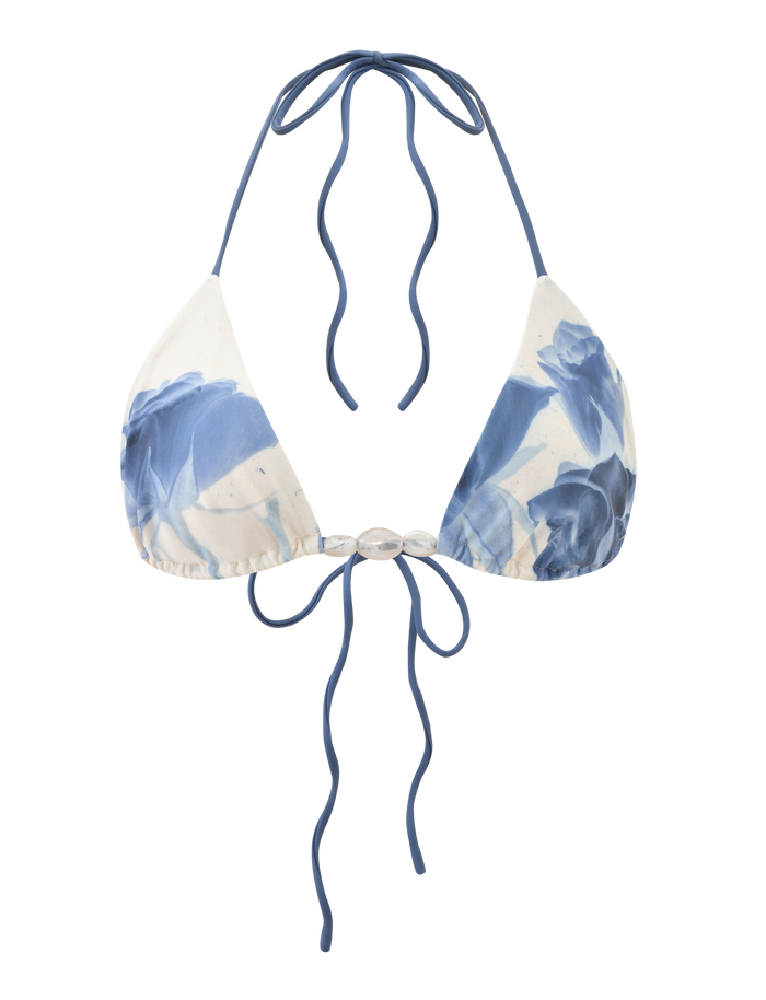 The TIGERMIST CYLAS BIKINI TOP - INDIGO FLORAL is a blue and white tie-dye halter neck bikini top with adjustable back ties and subtle rose design accents, shown on a plain background.