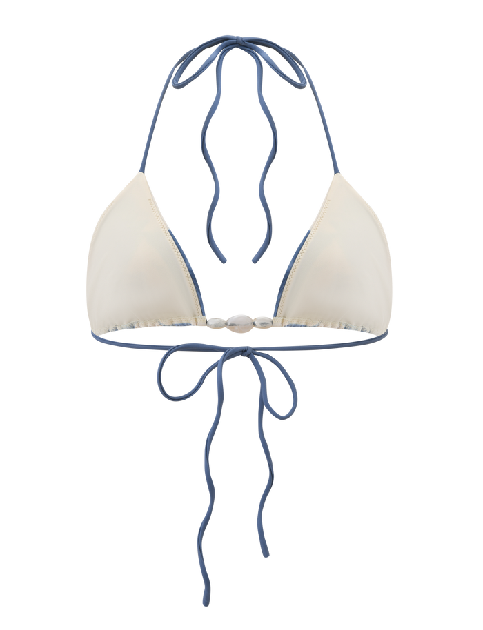 The CYLAS BIKINI TOP - INDIGO FLORAL by TIGERMIST is a cream floral bikini top with blue trim, halter neck ties, and a bow-tie back closure.
