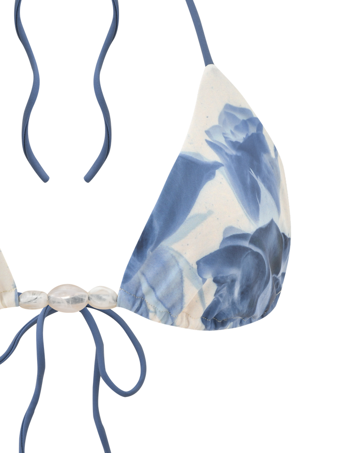 The TIGERMIST CYLAS BIKINI TOP in Indigo Floral features a halter neck, blue straps, blue and white floral design, and decorative translucent beads at the center.