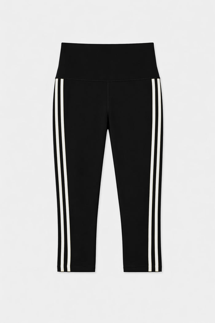 The SPLITS59 Ella High Waist Airweight Capri in Black/White features two vertical white stripes on each leg, combining comfort and style for any activity. Displayed on a plain white background.