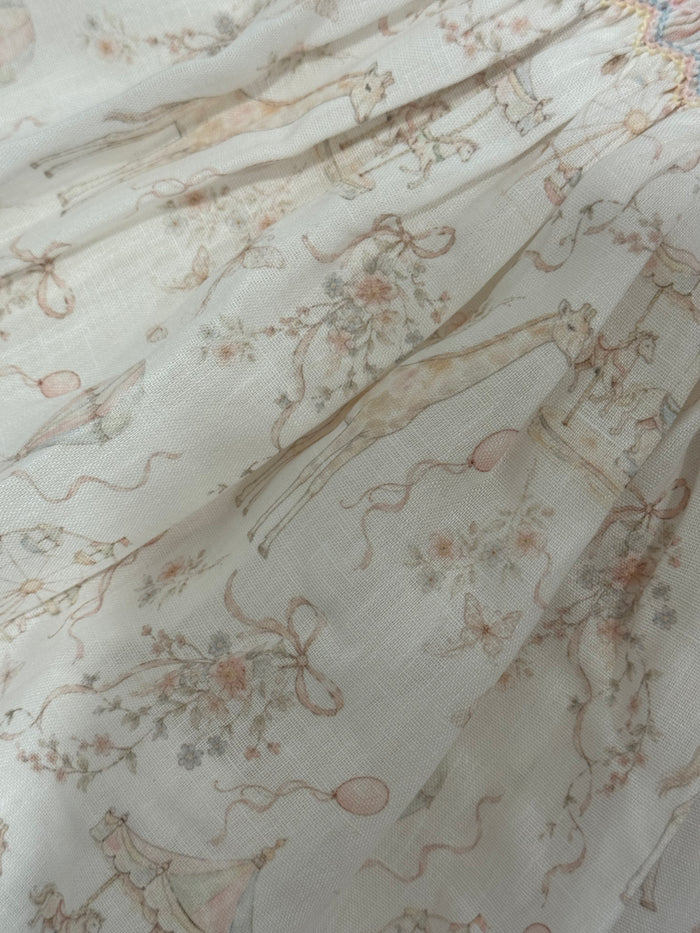 Close-up of pastel carousel print on Ella Handsmocked Girl Dress