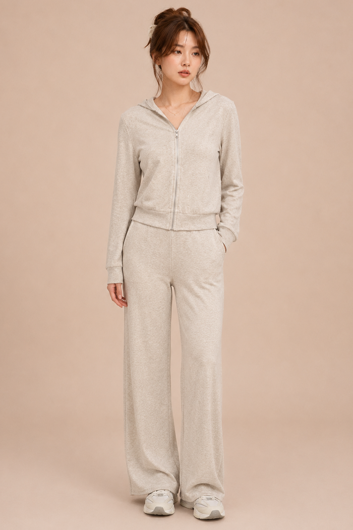 Woman wearing a beige cardigan and pants on a beige background