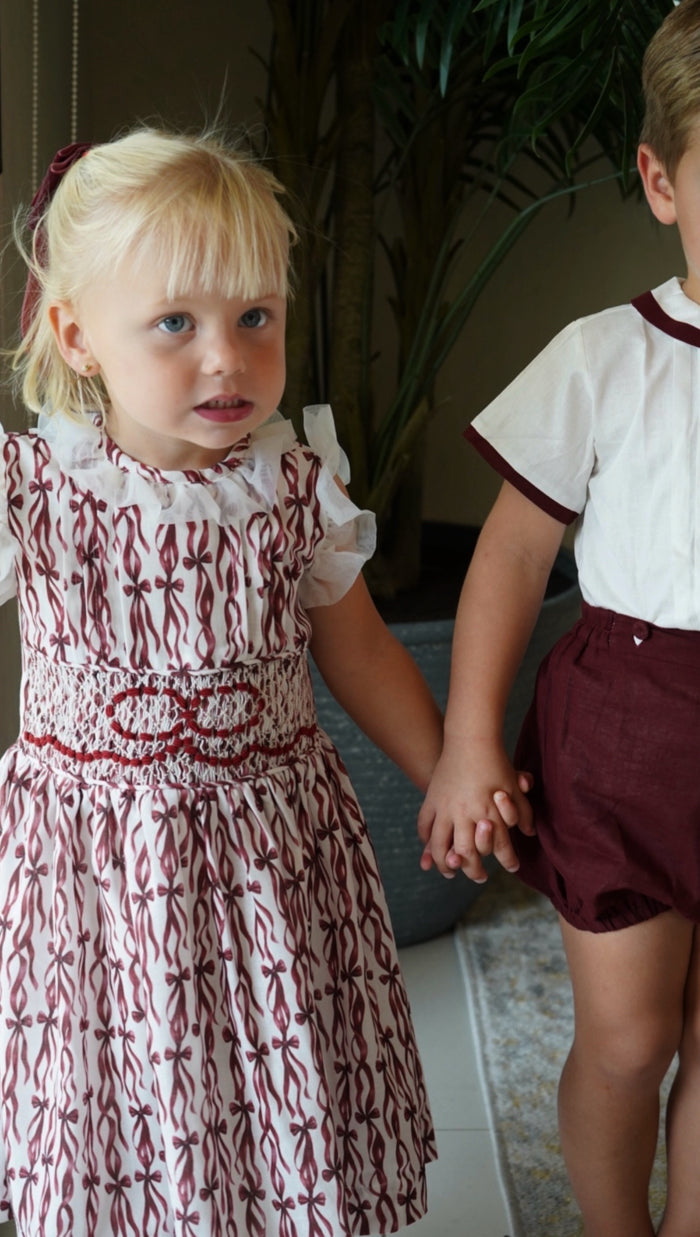 Girl wearing Every Day is a Gift Burgundy Christmas Handsmocked Dress