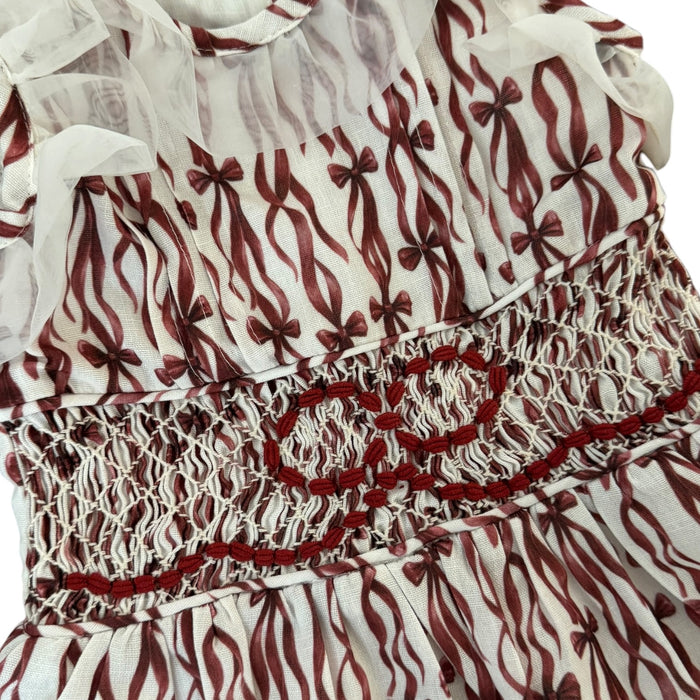 Close-up of intricate burgundy handsmocking on Every Day is a Gift Christmas Dress