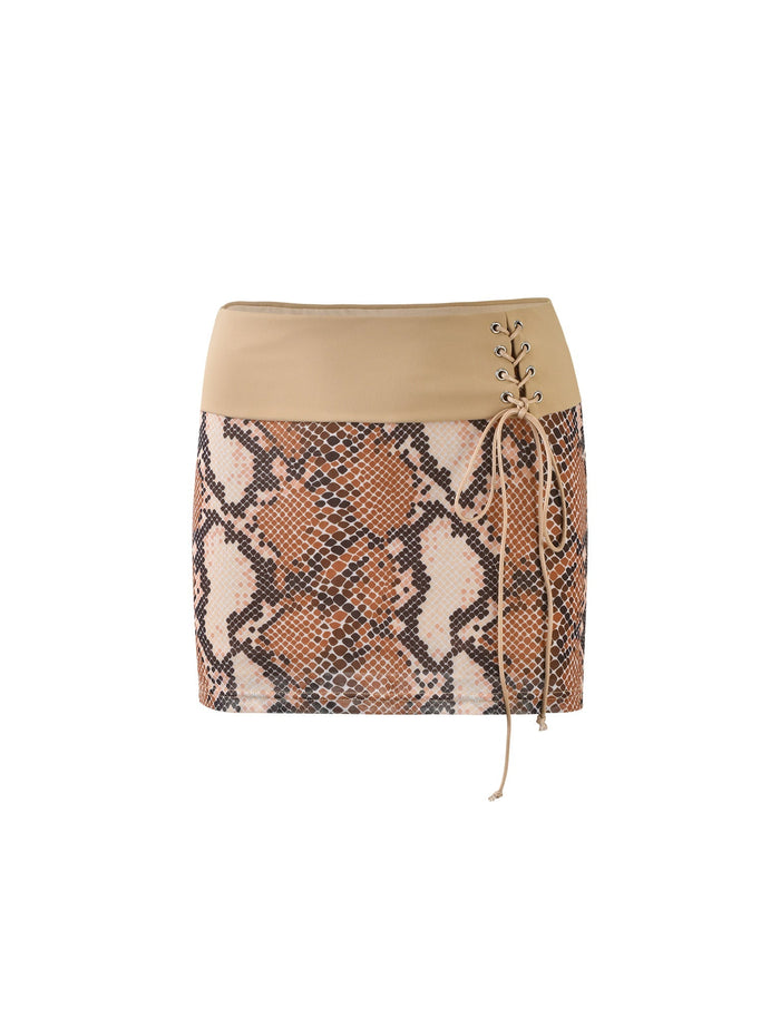 The TIGERMIST FALLON SKIRT - BROWN : SNAKE is a mini skirt featuring a beige waistband and a vibrant snake print pattern in shades of brown, cream, and black. The skirt is designed with a lace-up feature on the right side using beige laces.