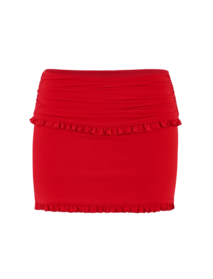The GINNY SKORT - RED by TIGERMIST features a flattering bodycon fit, bright red hue, ruched waist, and ruffle details along the top and bottom edges.