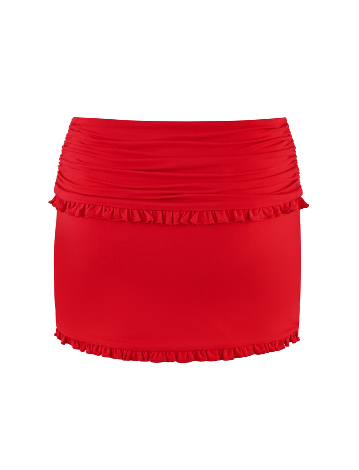 The GINNY SKORT - RED by TIGERMIST is a red, high-waisted mini skort with a bodycon fit, featuring ruching and ruffle details along the top and bottom edges, shown on a white background.