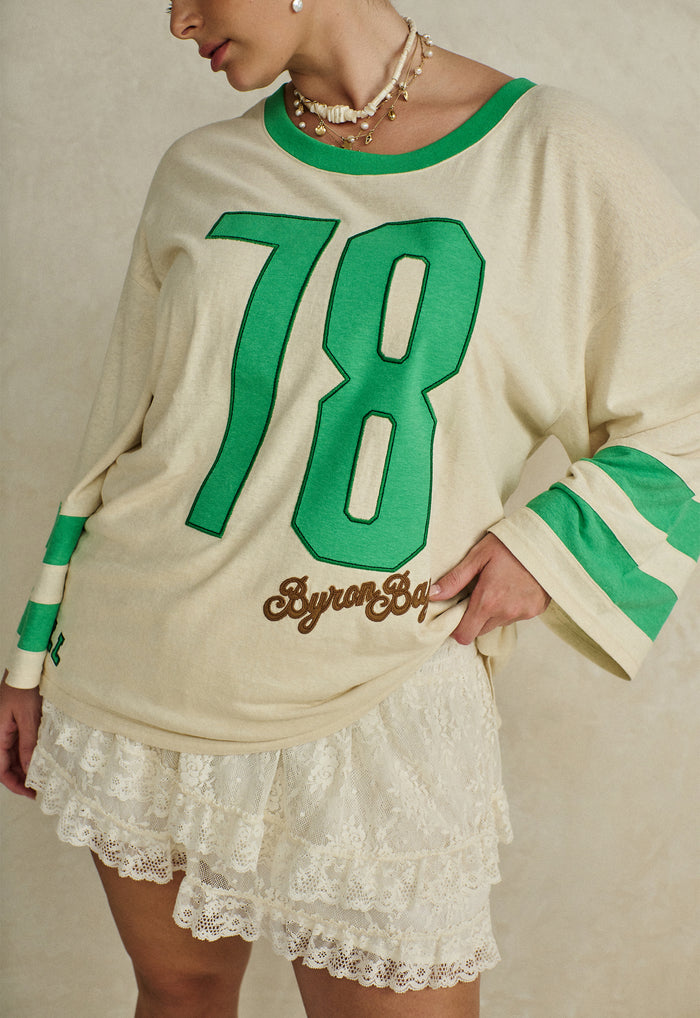 Front detail of hemp organic cotton tee showing green 78 applique, contrast sleeve stripes and Byron Bay embroidery