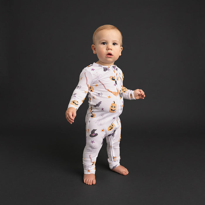 Baby standing wearing the Posh Peanut Irving Convertible One Piece.