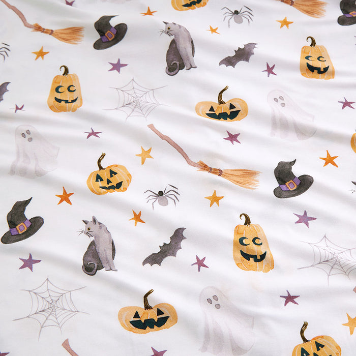 Close-up of the Irving print — scattered Halloween icons including pumpkins and bats on white bamboo viscose fabric.
