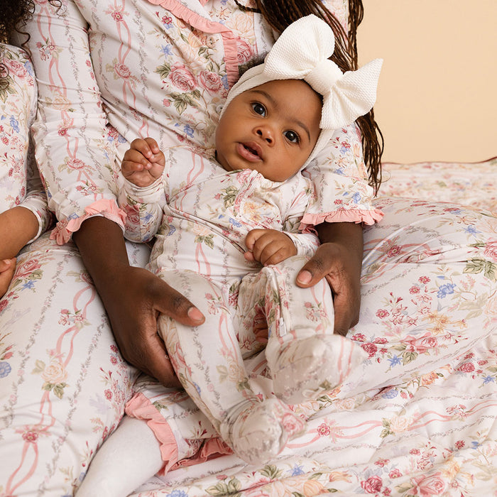 Two babies together in coordinating Janey print outfits, close-up lifestyle shot