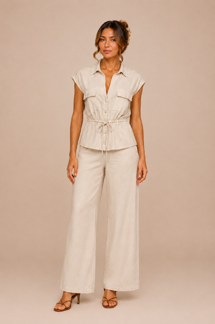 Woman wearing a beige outfit with wide-leg pants on a beige background