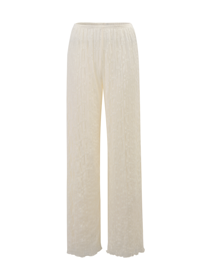 The KATERINA PANT - IVORY LACE by TIGERMIST features a high-waisted, wide-leg fit with floral lace, an elasticated waist, and a lightweight, semi-sheer textured design.