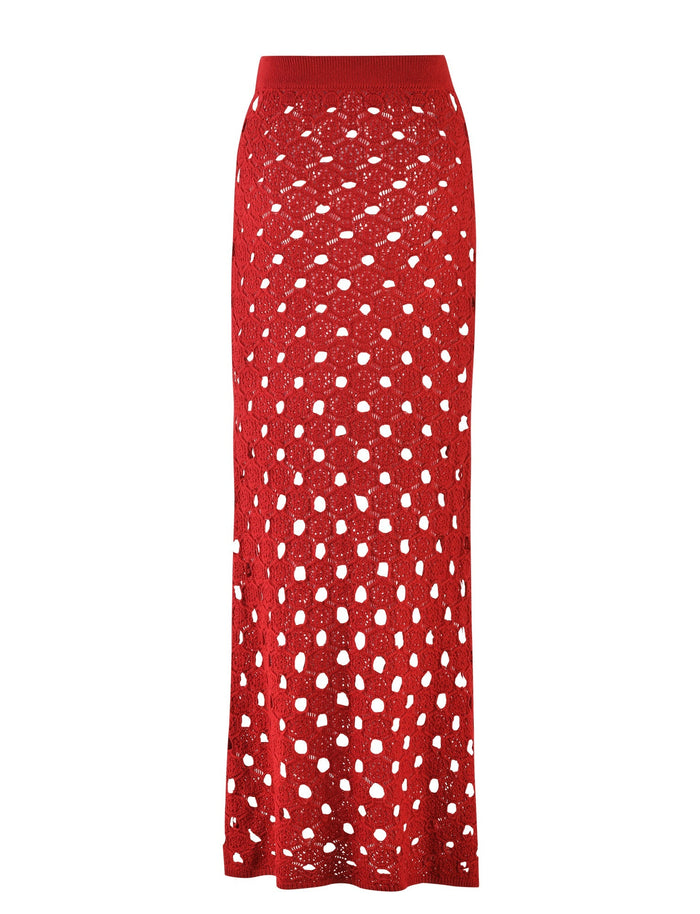 The Kincade Skirt in Cherry Red from TigerMist is a long, high-waisted crochet skirt that features an intricate open weave pattern with large circular cutouts throughout. It is fitted at the waist and gradually flares out slightly towards the hem.