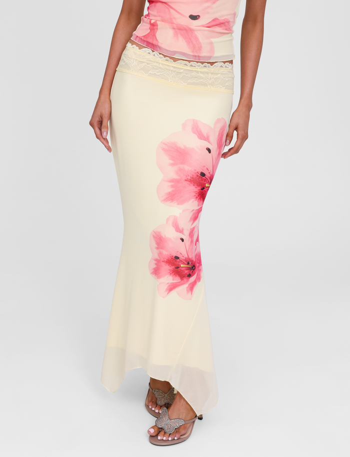 A woman wears the TIGERMIST LILLIAN SKIRT in yellow, styled with a matching top and jeweled butterfly sandals.