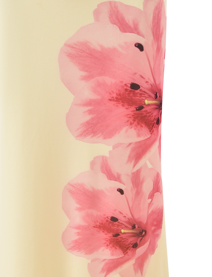 Two large pink flowers with dark centers and yellow stamens bloom across the soft yellow LILLIAN SKIRT by TIGERMIST, making it a perfect floral statement piece.