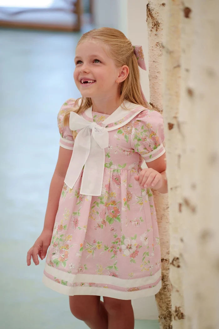 Girl wearing pink floral sailor dress with white collar