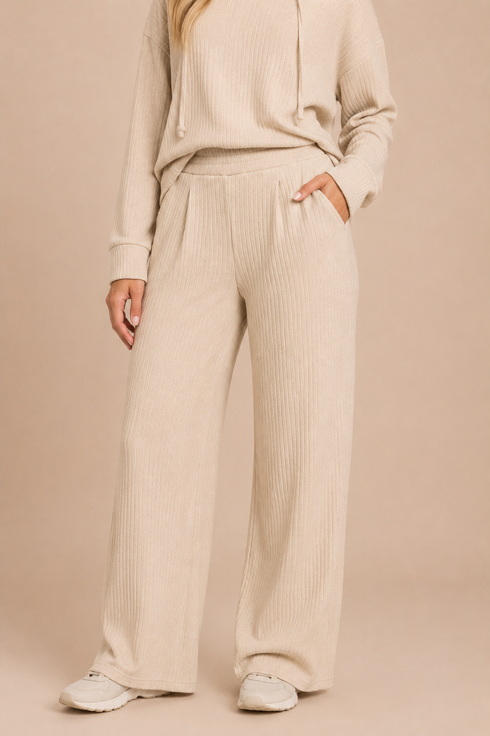 Woman wearing a beige ribbed knit outfit on a beige background
