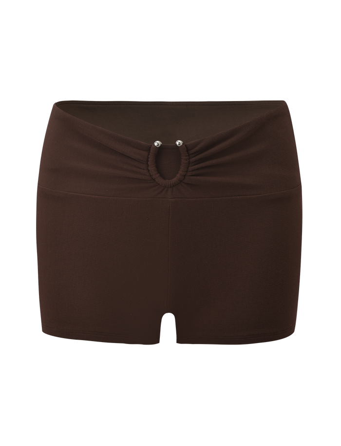 The LUNARA SHORT - CHOCOLATE by TIGERMIST features a gathered waistband, ruched front, small oval cutout, and two metallic stud accents.