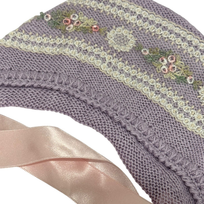 Close-up of ivory lace trim and soft purple knit on Aida baby set