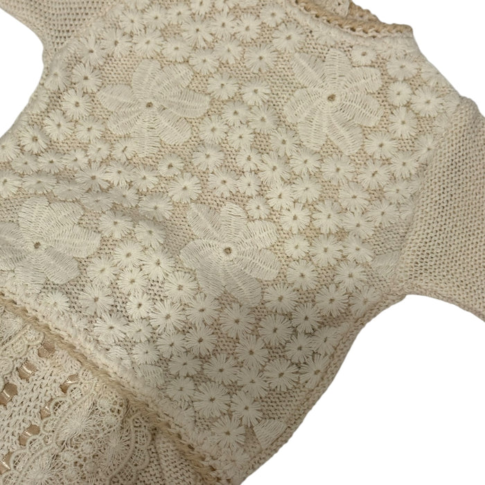 Close-up of delicate floral lace detailing on Judith II knitted baby set